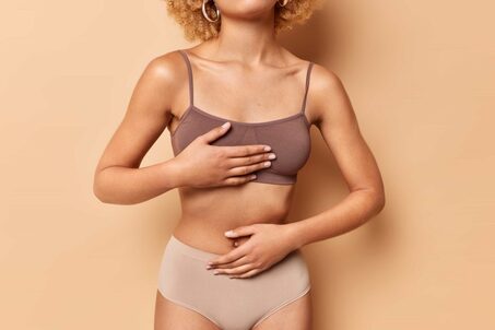 faceless woman keeps hands body dressed top panties has perfect figure tight hips poses against brown background cropped shot unrecognizable female model after plastic surgery 1 1024x683 1