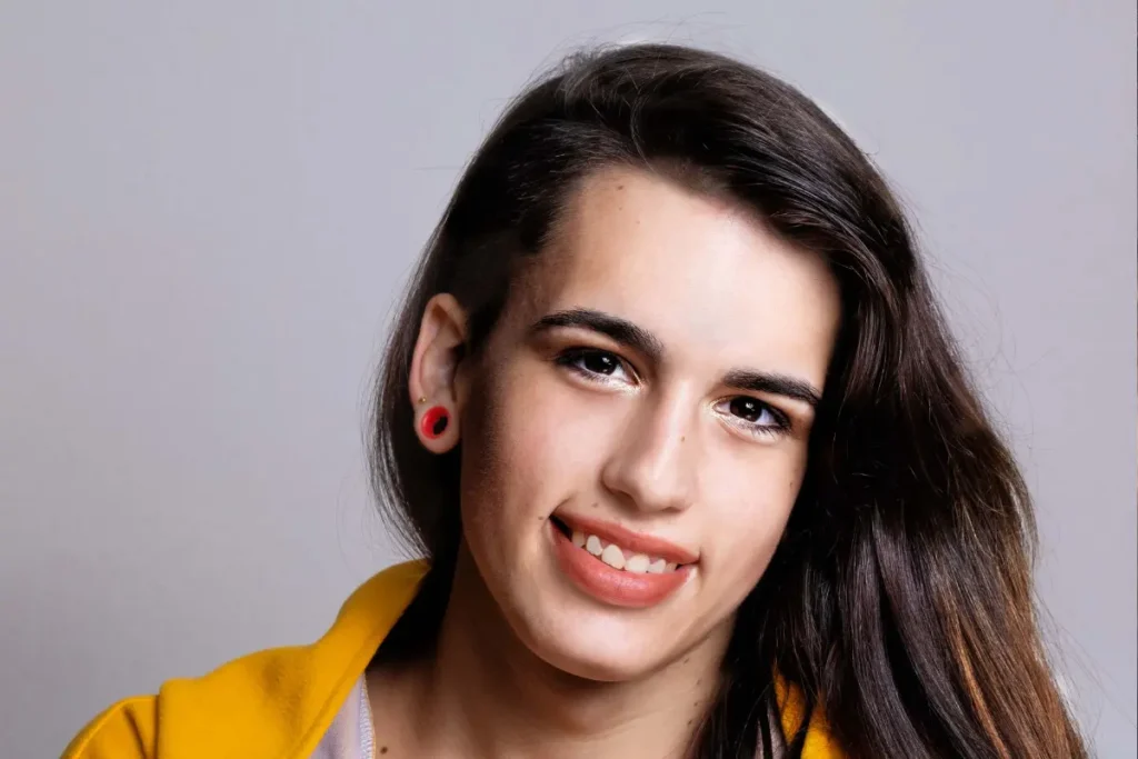 smiling person with long styled hair after male-to-female hair restoration